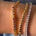 Close-up of a person's wrist wearing multiple bracelets on a blurred background