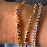 Close-up of a person's wrist wearing multiple bracelets on a blurred background